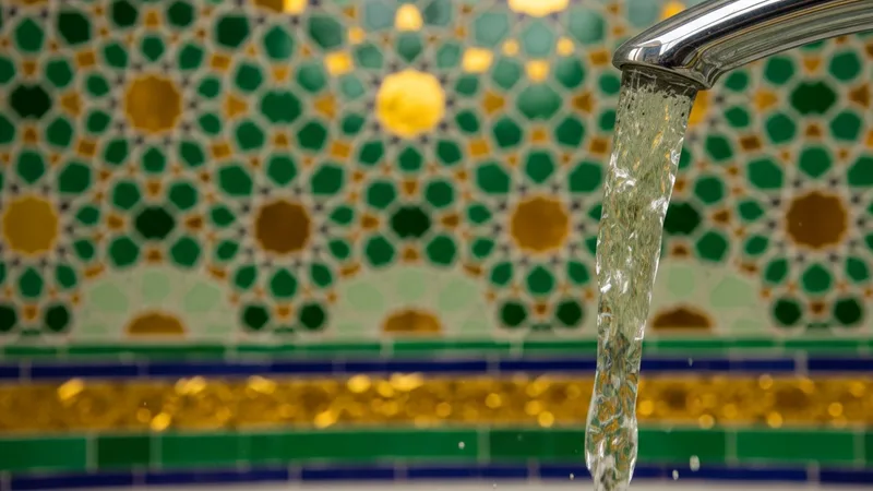 Temiz suyun aktığı bir musluk, etrafında İslami motifler ve yeşil tonları