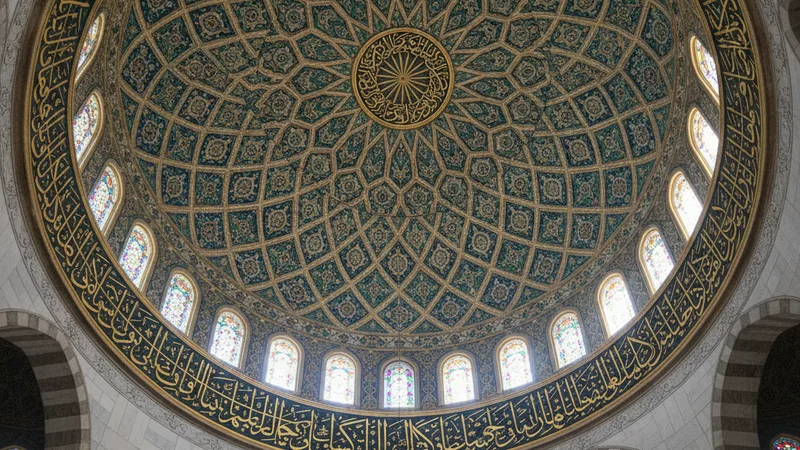 Bir caminin kubbesinin içinden ışık süzülürken görünen İslami hat sanatı ve geometrik desenler.